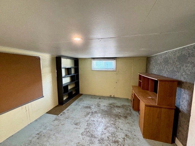 an empty room with a desk and a bulletin board