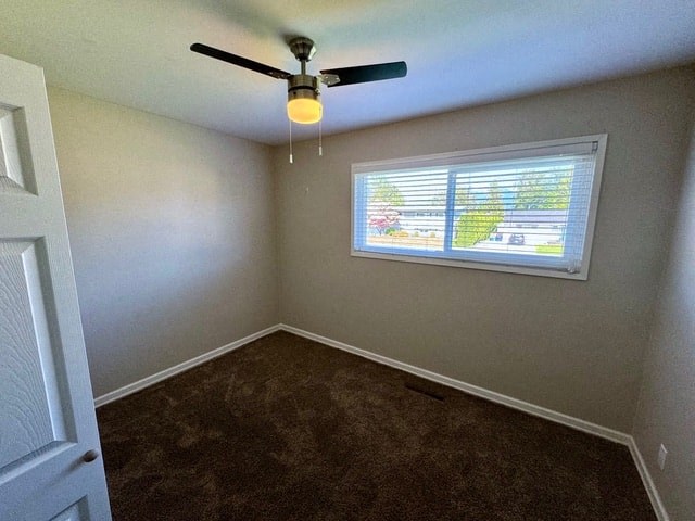 an empty room with a ceiling fan and a window