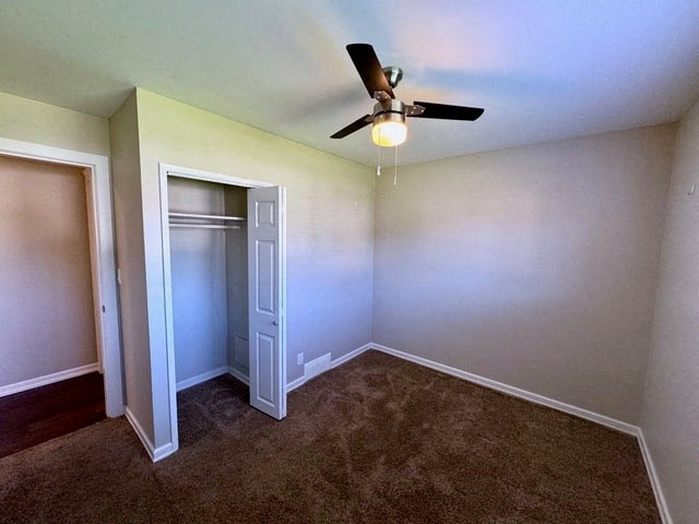 a empty room with a ceiling fan and a closet