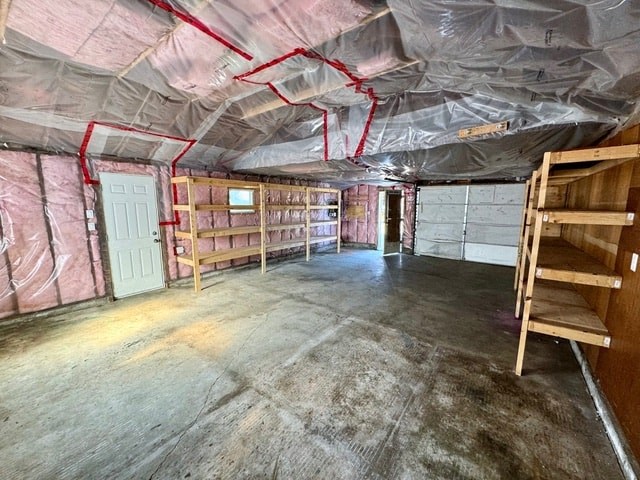 the inside of a building covered in plastic with shelves and a door