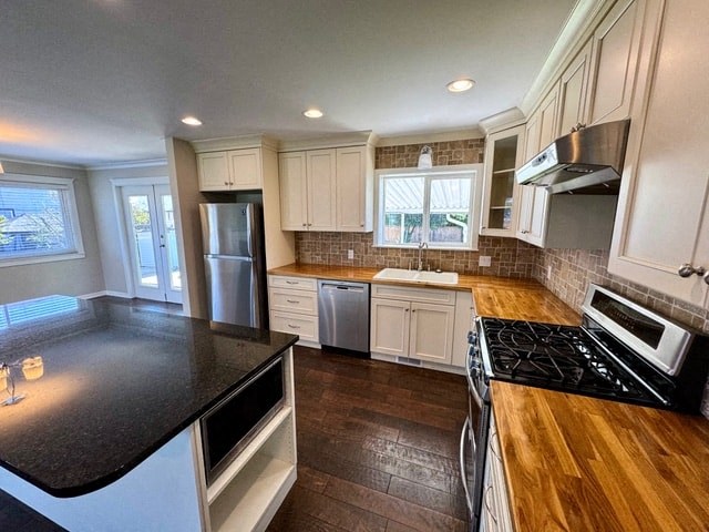 a kitchen with white cabinets and black counter tops