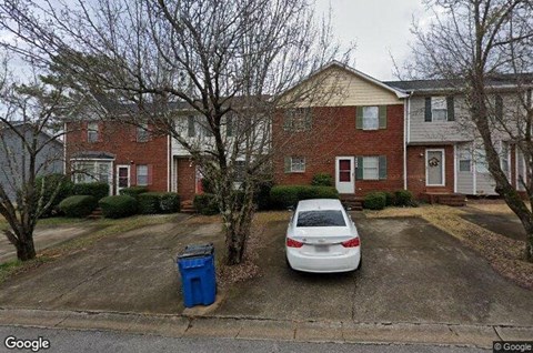 a white car parked in front of a house