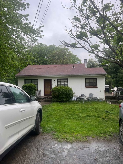 a white house with a car parked in front of it