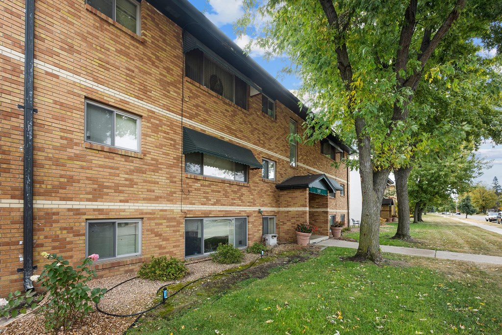 A brick building with a tree in front.