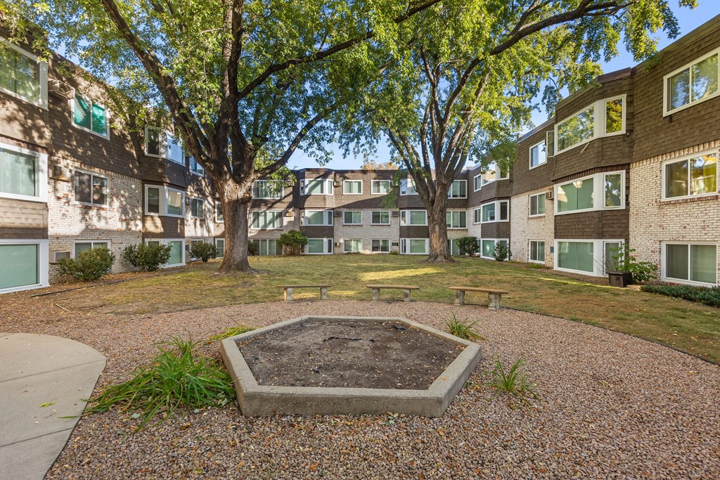 A courtyard with a tree and a concrete structure in the middle.
