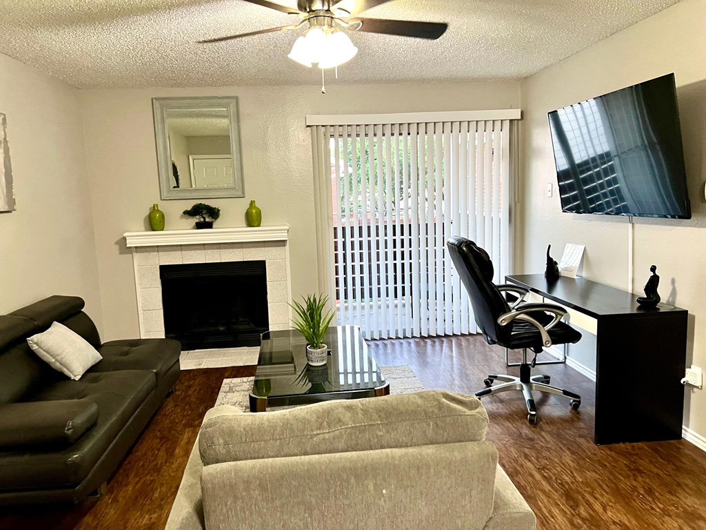 an open living room with a couch and a chair and a fireplace