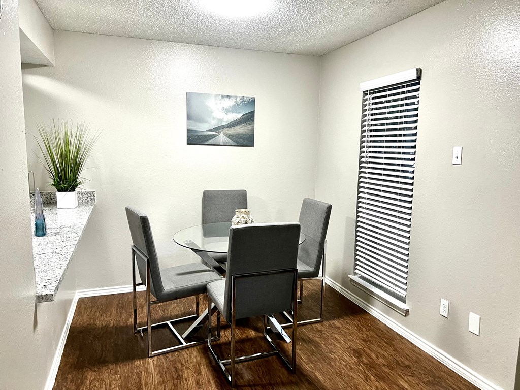 a dining room with a table and chairs and a window