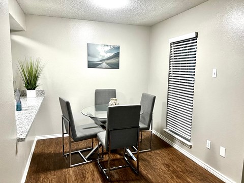 a dining room with a table and chairs and a window