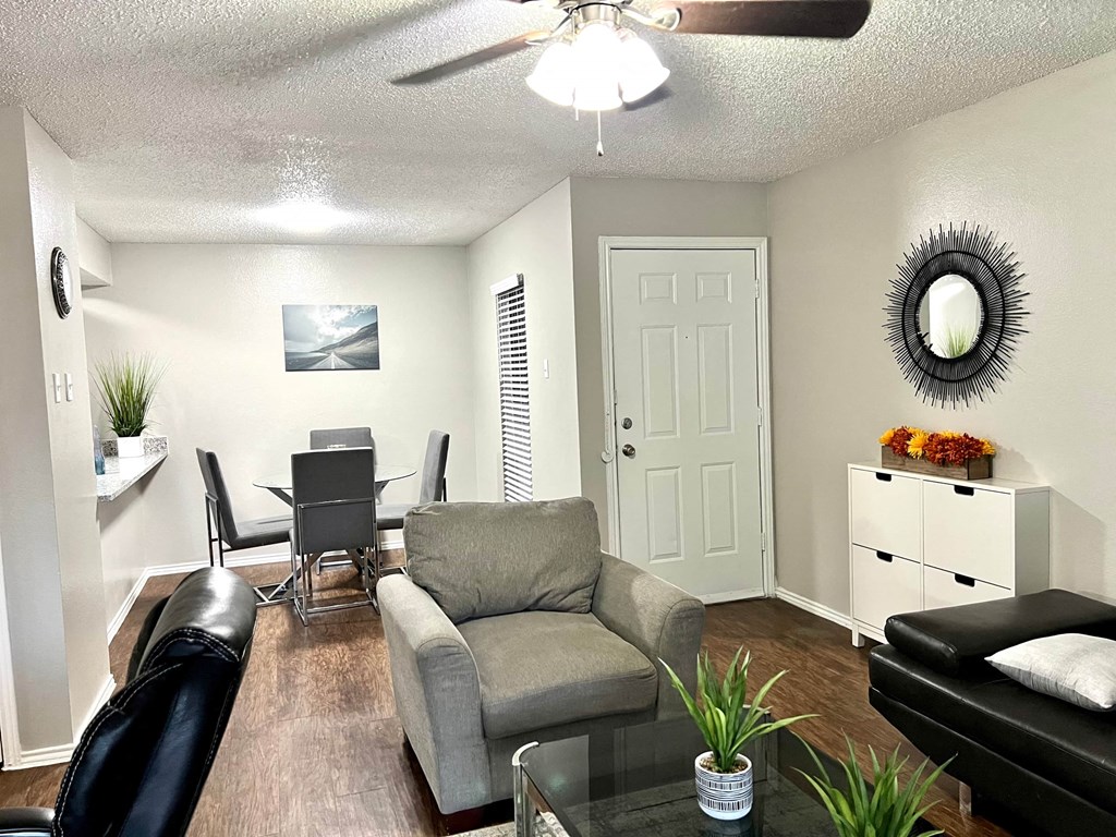 a living room and dining room with a table and a ceiling fan