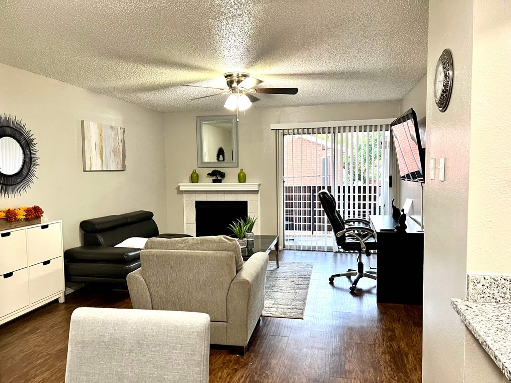 a living room with a couch and a chair in front of a fireplace