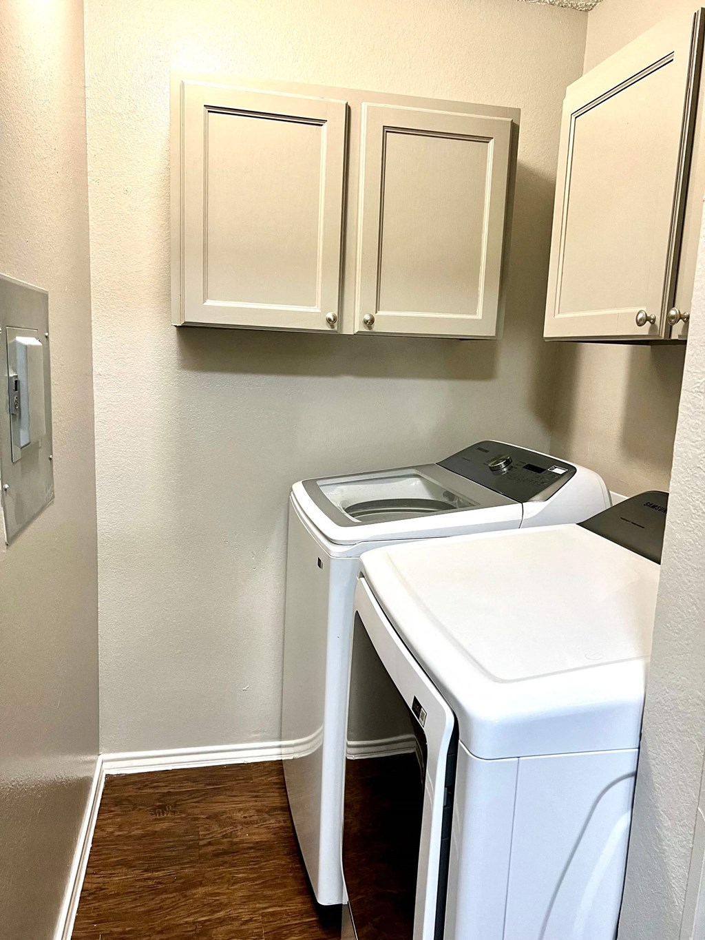 a small laundry room with white cabinets and a washer and dryer