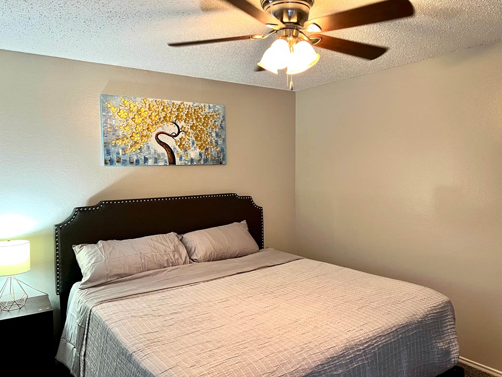 a bedroom with a bed and a ceiling fan