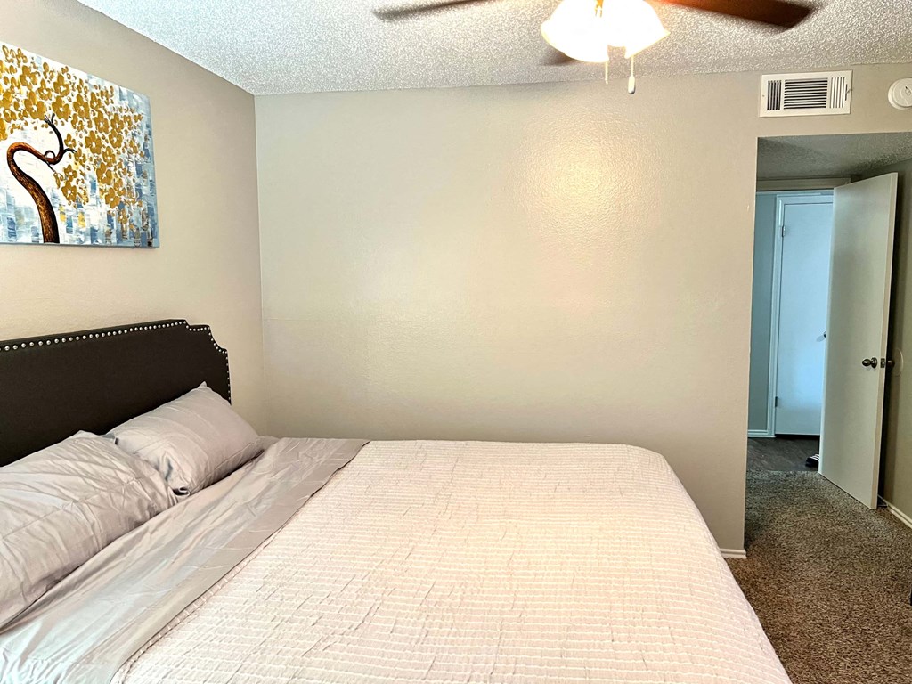 a bedroom with a large bed and a ceiling fan