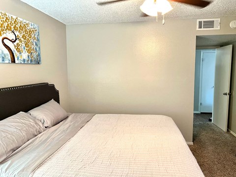 a bedroom with a large bed and a ceiling fan