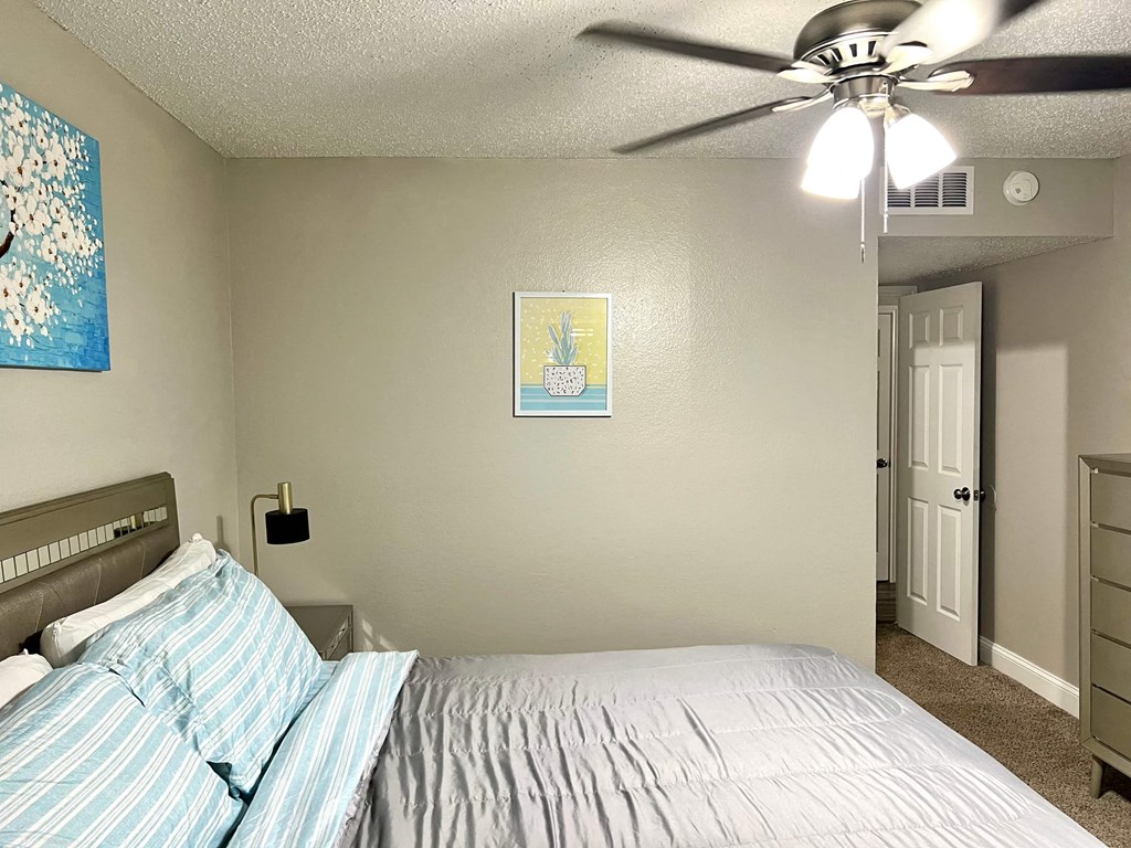 a bedroom with a bed and a ceiling fan