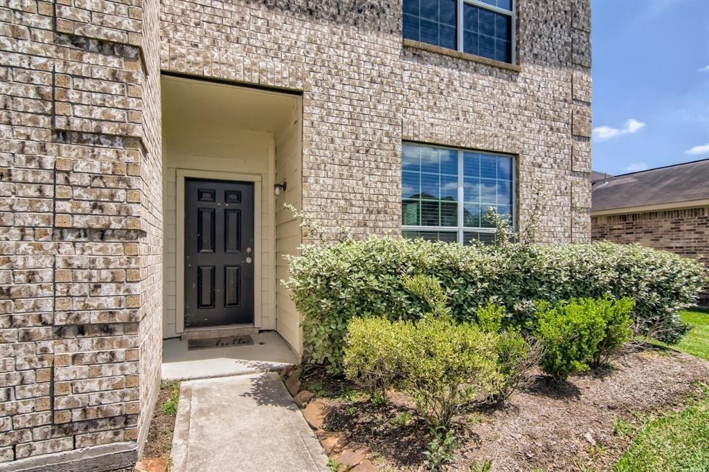 the front of a brick house with a black door