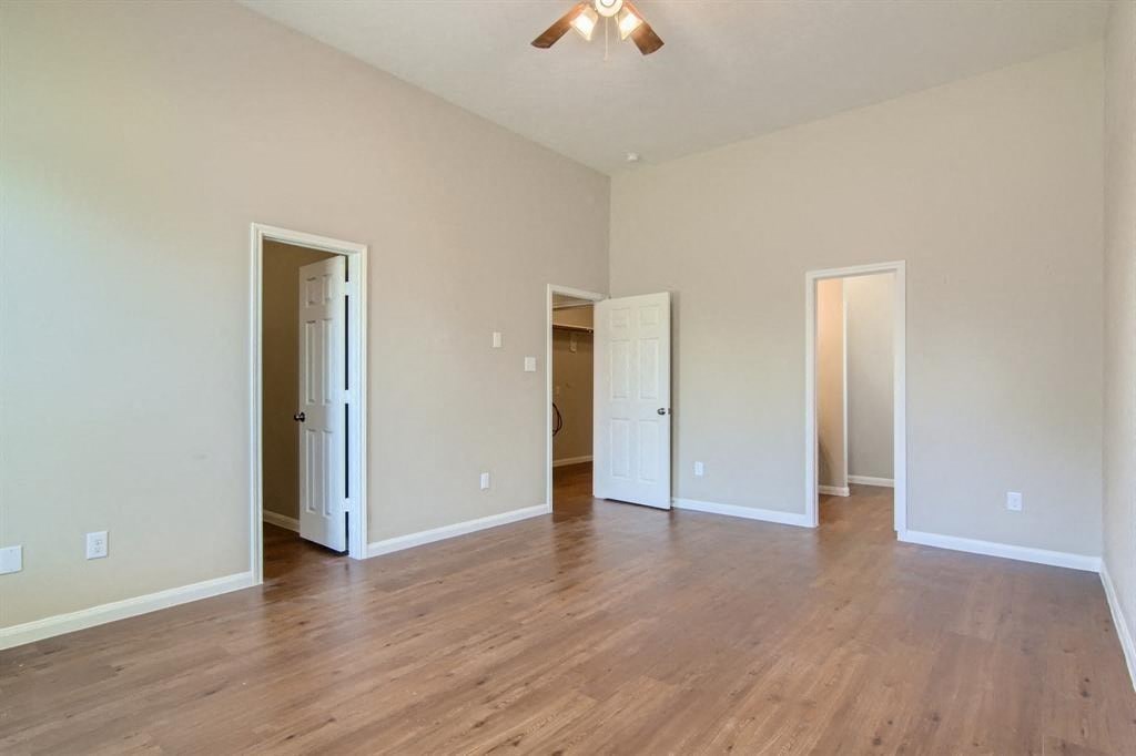 a living room with a hard wood floor and white walls