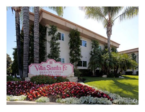 A sign for Villa Santa Fe reads "Quality Living" in front of a building.