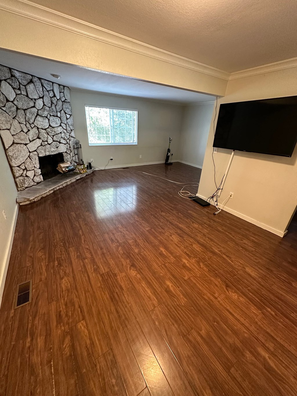 a living room with a stone fireplace and a tv