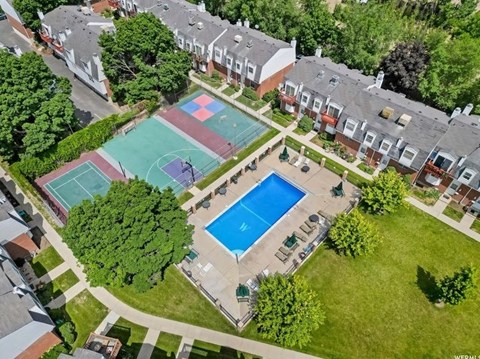 an aerial view of a house with a tennis court and a pool