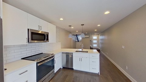 a kitchen with white cabinets and a stove and a microwave
