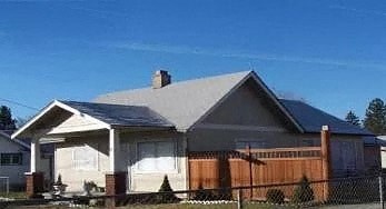 a house with a gray roof and a wooden fence