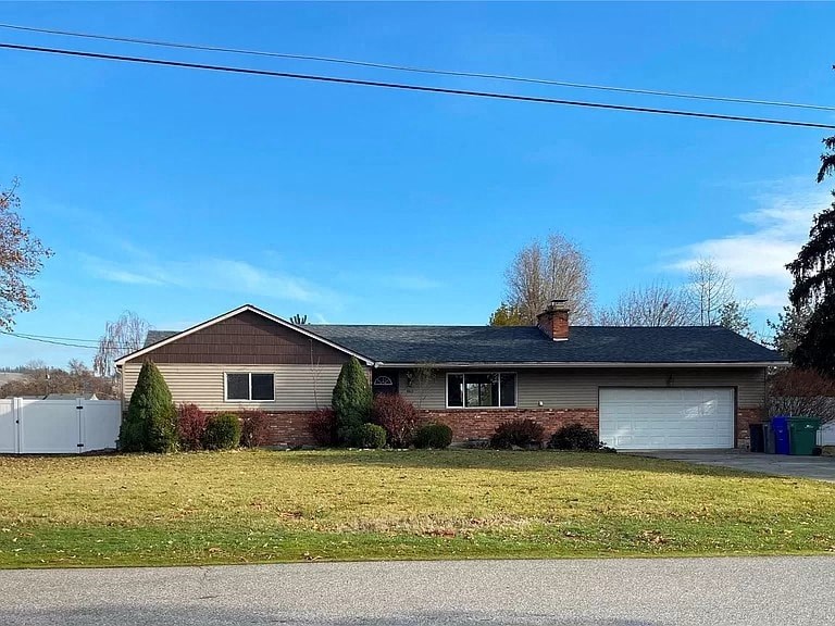 a house with a yard and a white garage door