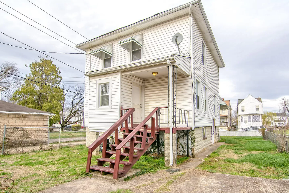 the front of a white house with red stairs