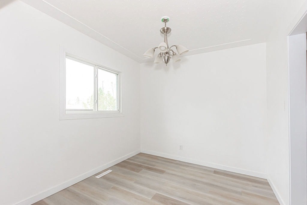 an empty room with a ceiling fan and a window