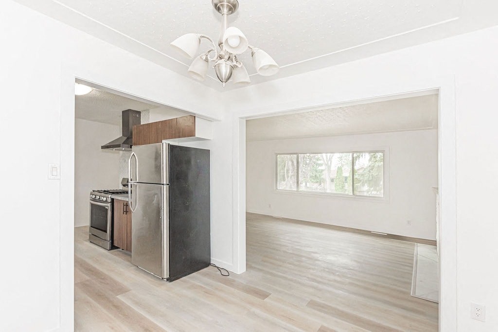 a kitchen with a refrigerator and a stove in a empty room