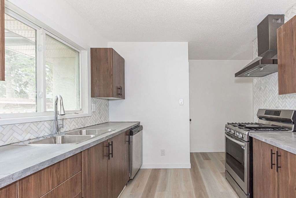 an empty kitchen with wooden cabinets and a sink