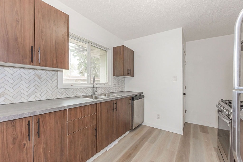 an empty kitchen with wooden cabinets and a window