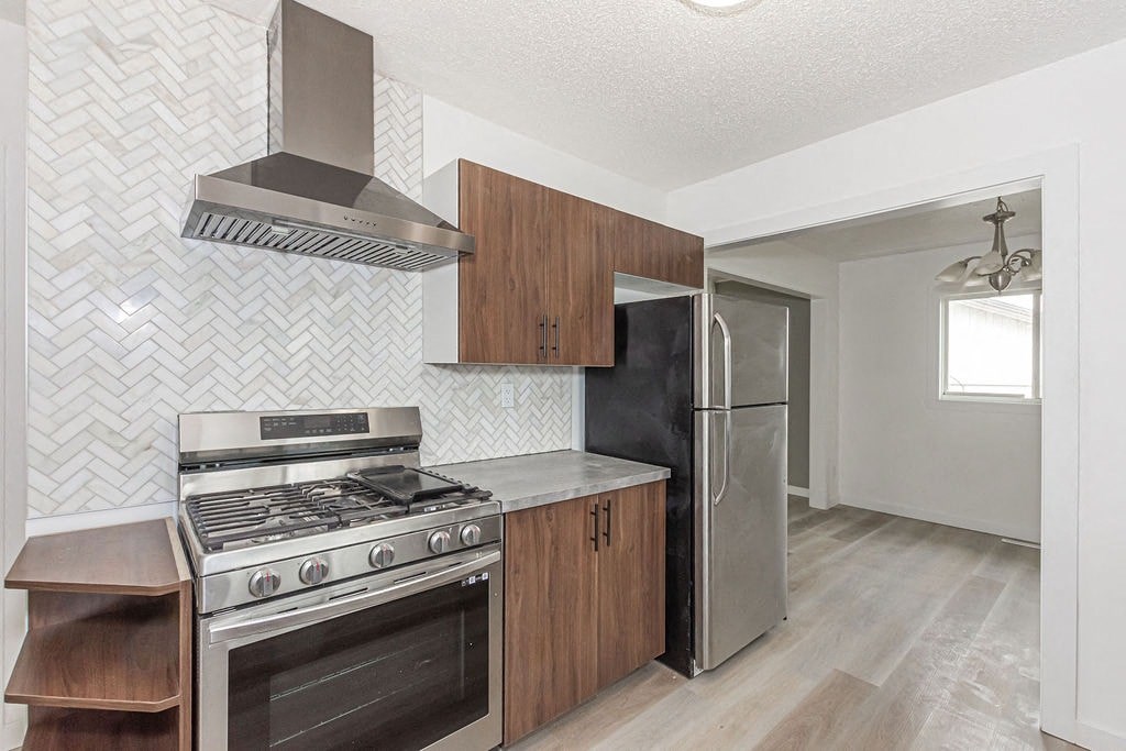 a kitchen with stainless steel appliances and wooden cabinets