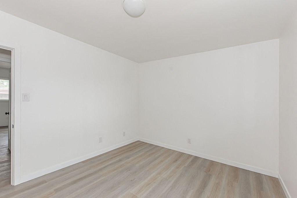 an empty room with white walls and wooden floors