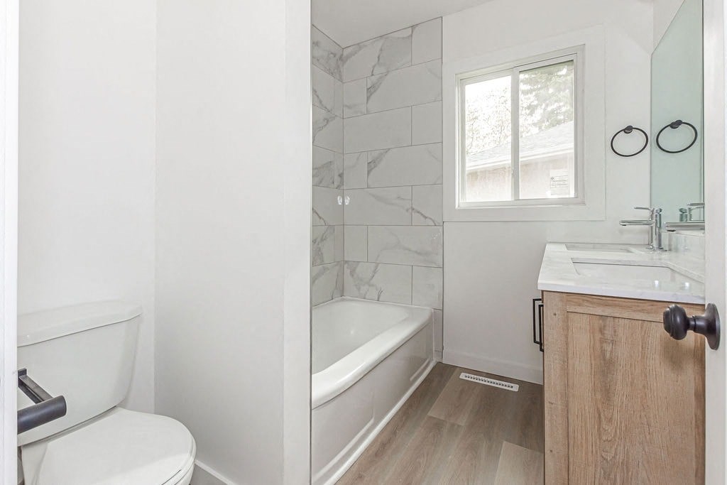 a white bathroom with a tub and a toilet and a sink