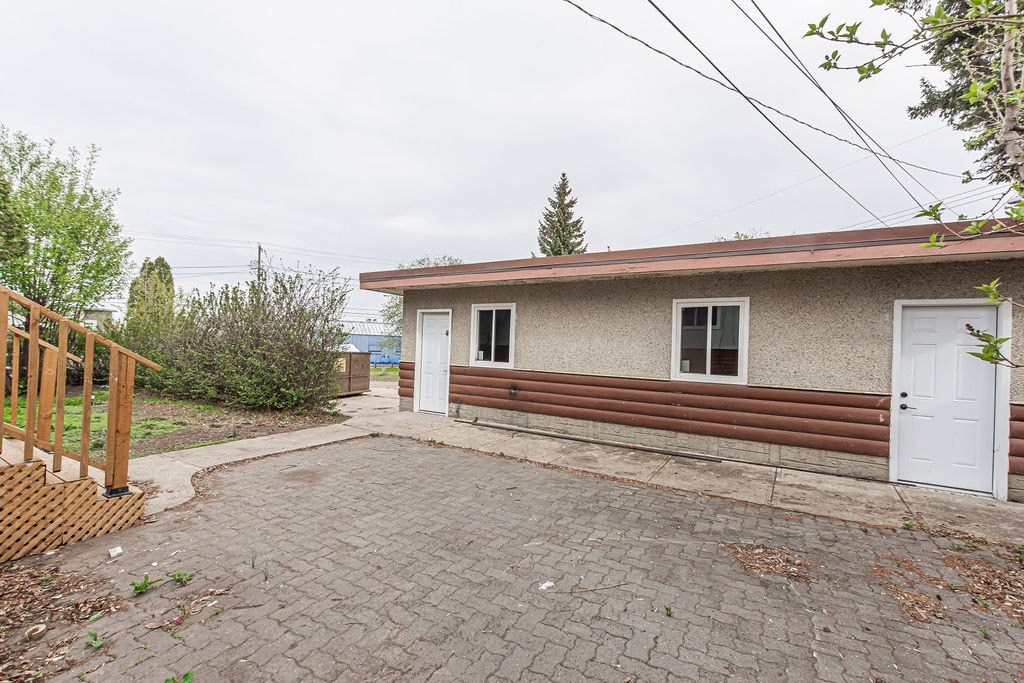 a small house with a brick driveway and a white door