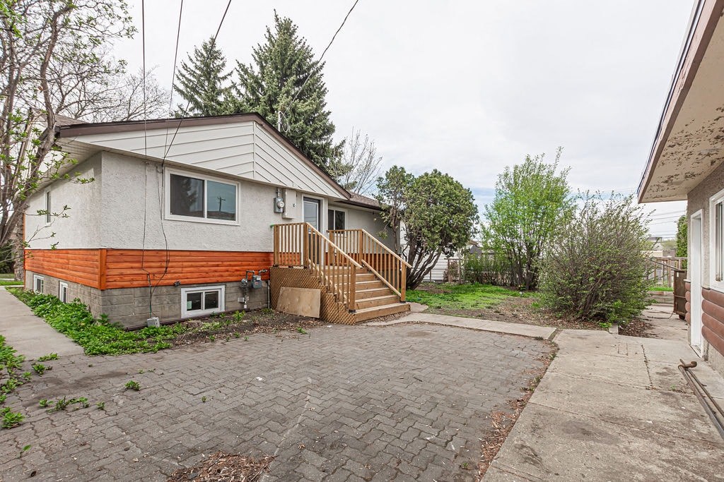 the front of a house with a brick driveway and a porch