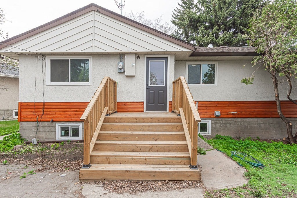 the front of a house with a wooden porch and stairs