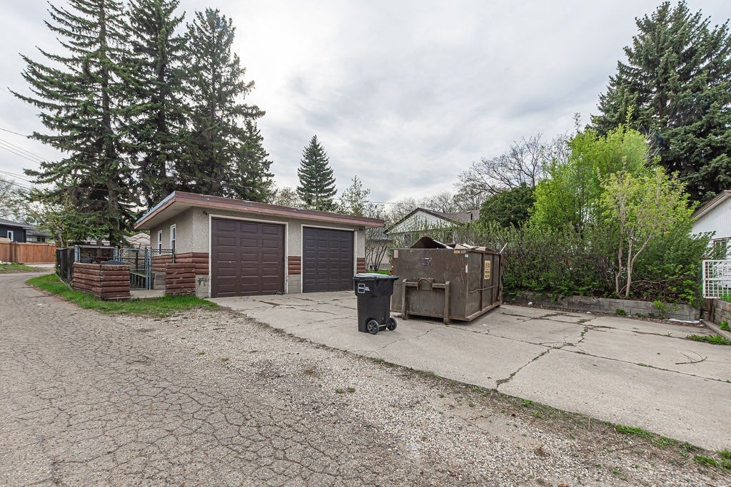 a house with a driveway and a trash can in front of it