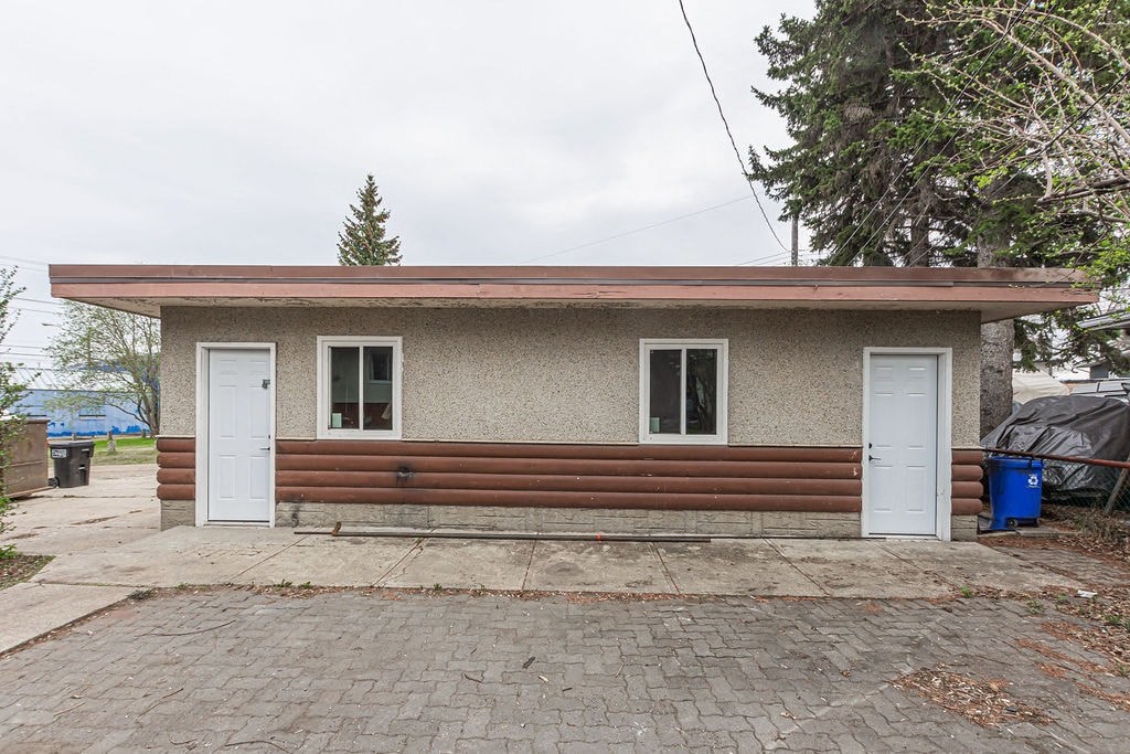 the front of a small house with two doors and a driveway