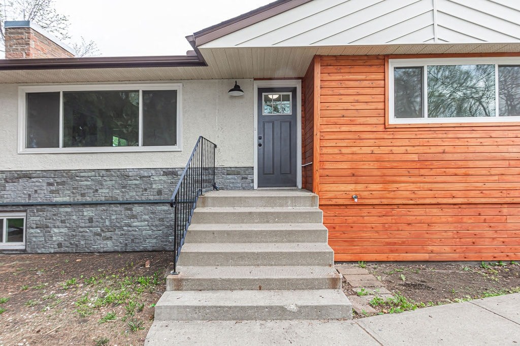 the front of a house with steps and a blue door