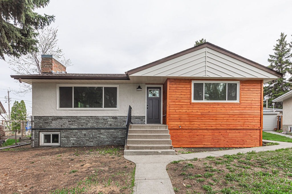 the front of a house with concrete steps and a wooden