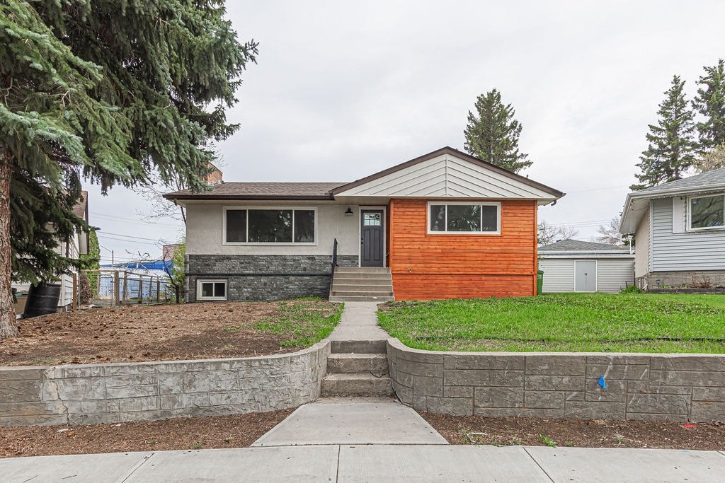 a house with a wooden front door and a sidewalk