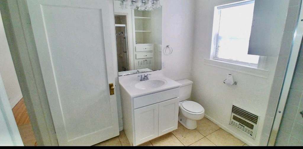 a bathroom with a sink toilet and a window