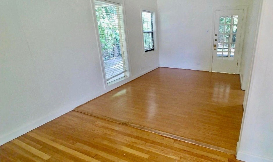 a living room with a hard wood floor and a door