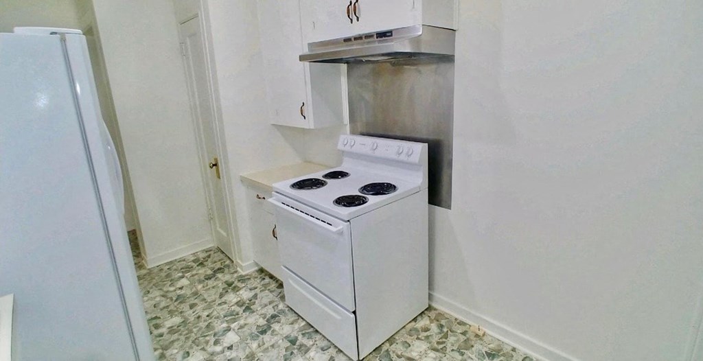 a small kitchen with a stove and a refrigerator