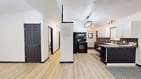 an open kitchen and living room with a black door