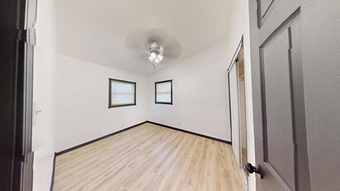 an empty living room with white walls and wood floors