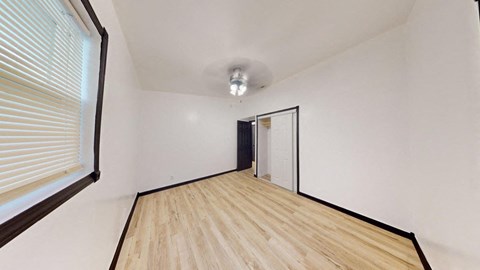 an empty room with wood floors and a large window