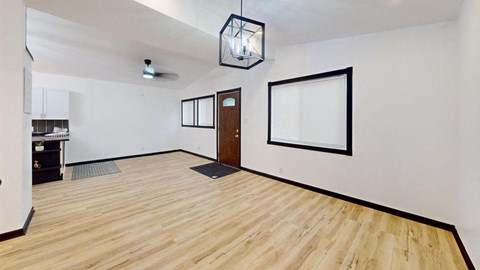 an empty living room with white walls and wood floors